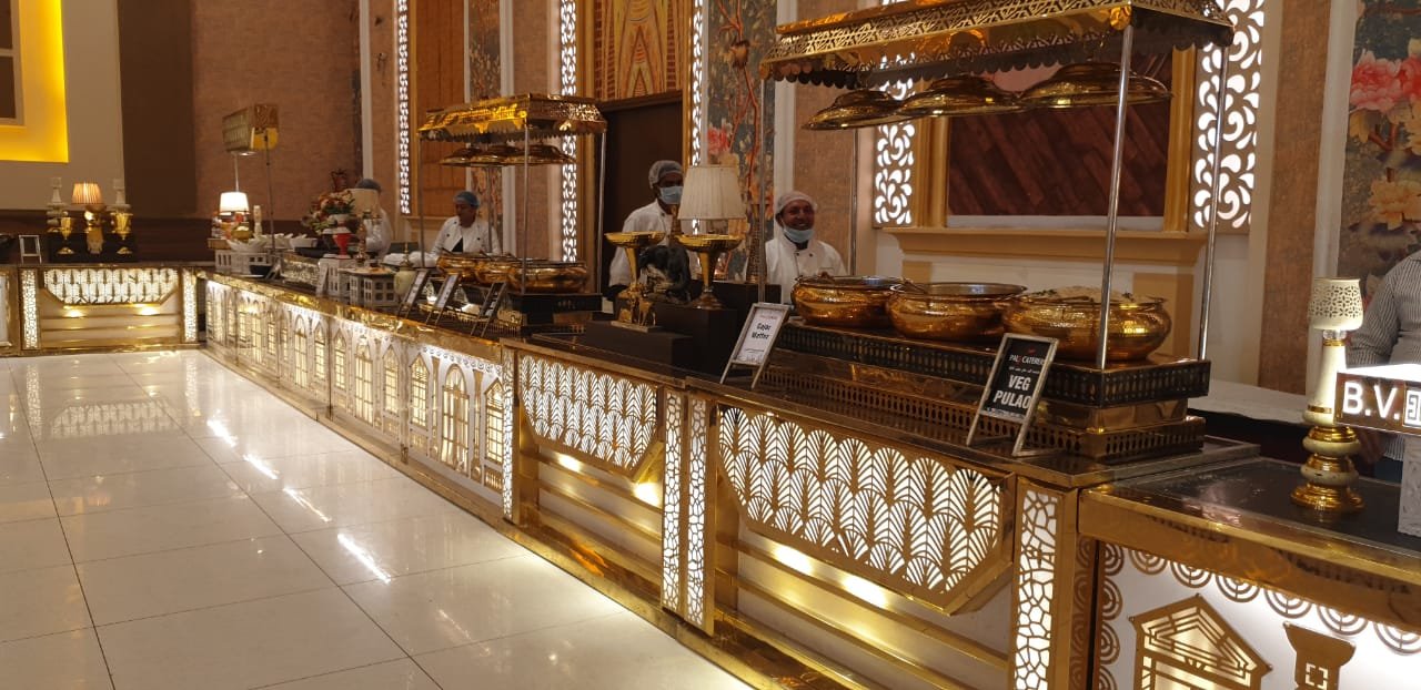 Bride and groom smiling at each other through green leaves